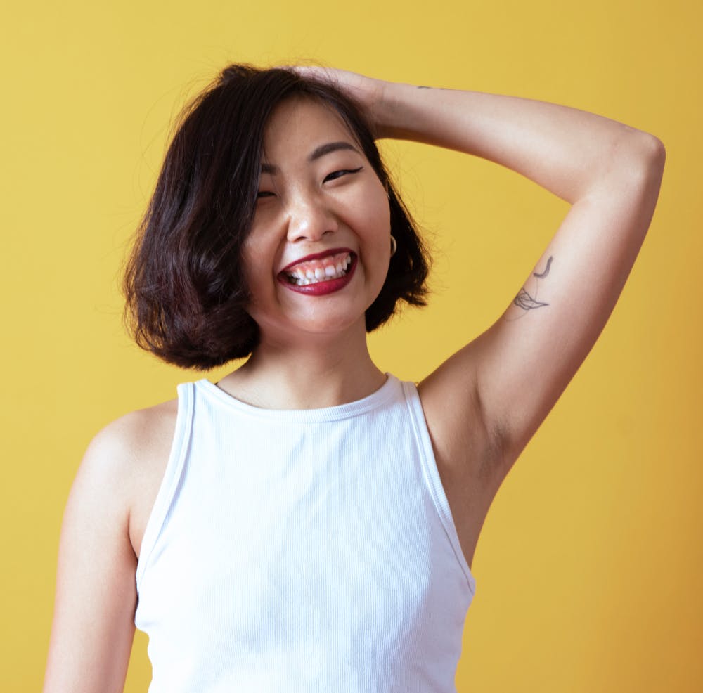 Woman smiling yellow background